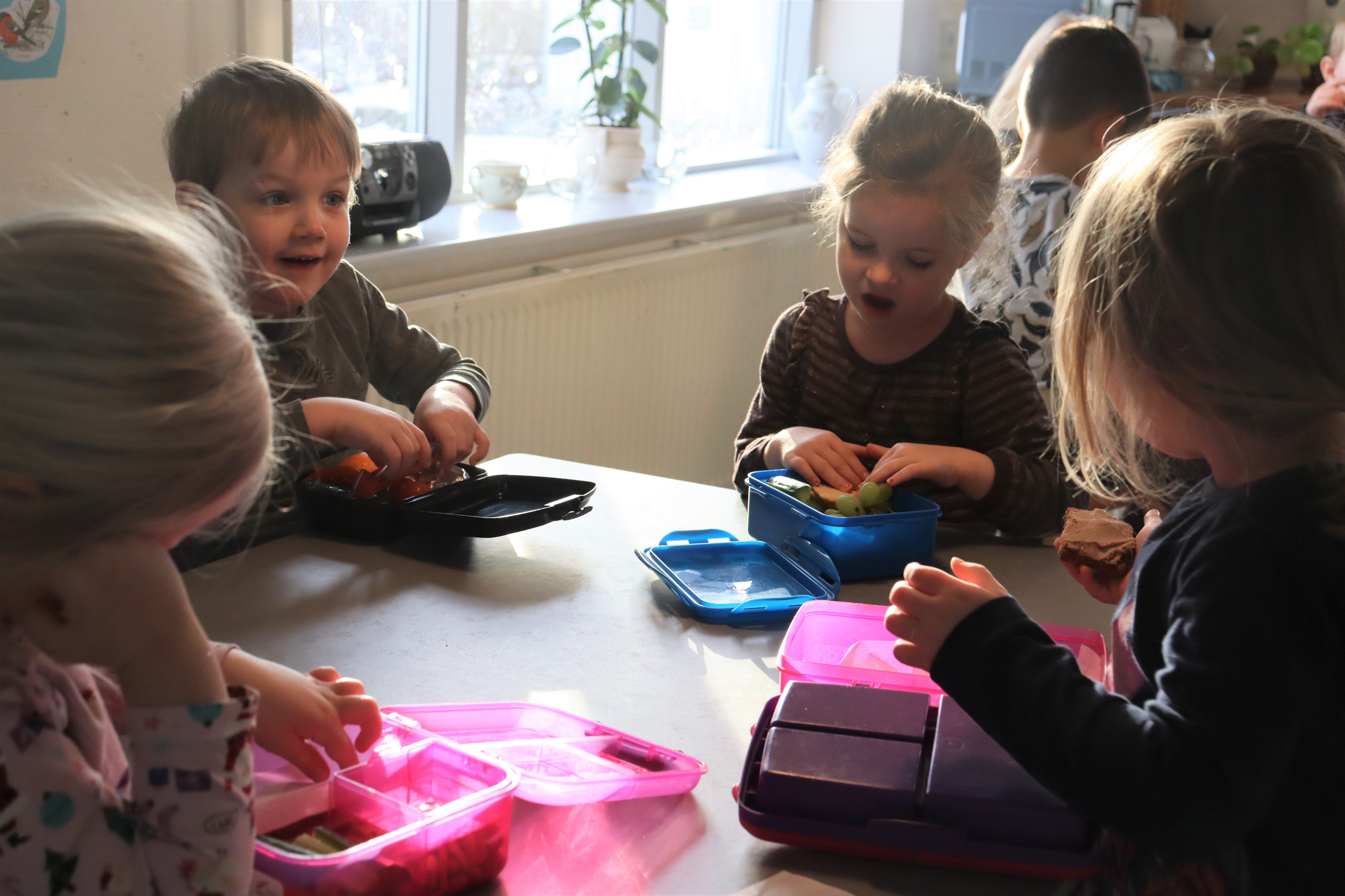 Børn sidder og spiser madpakke rundt om bordet
