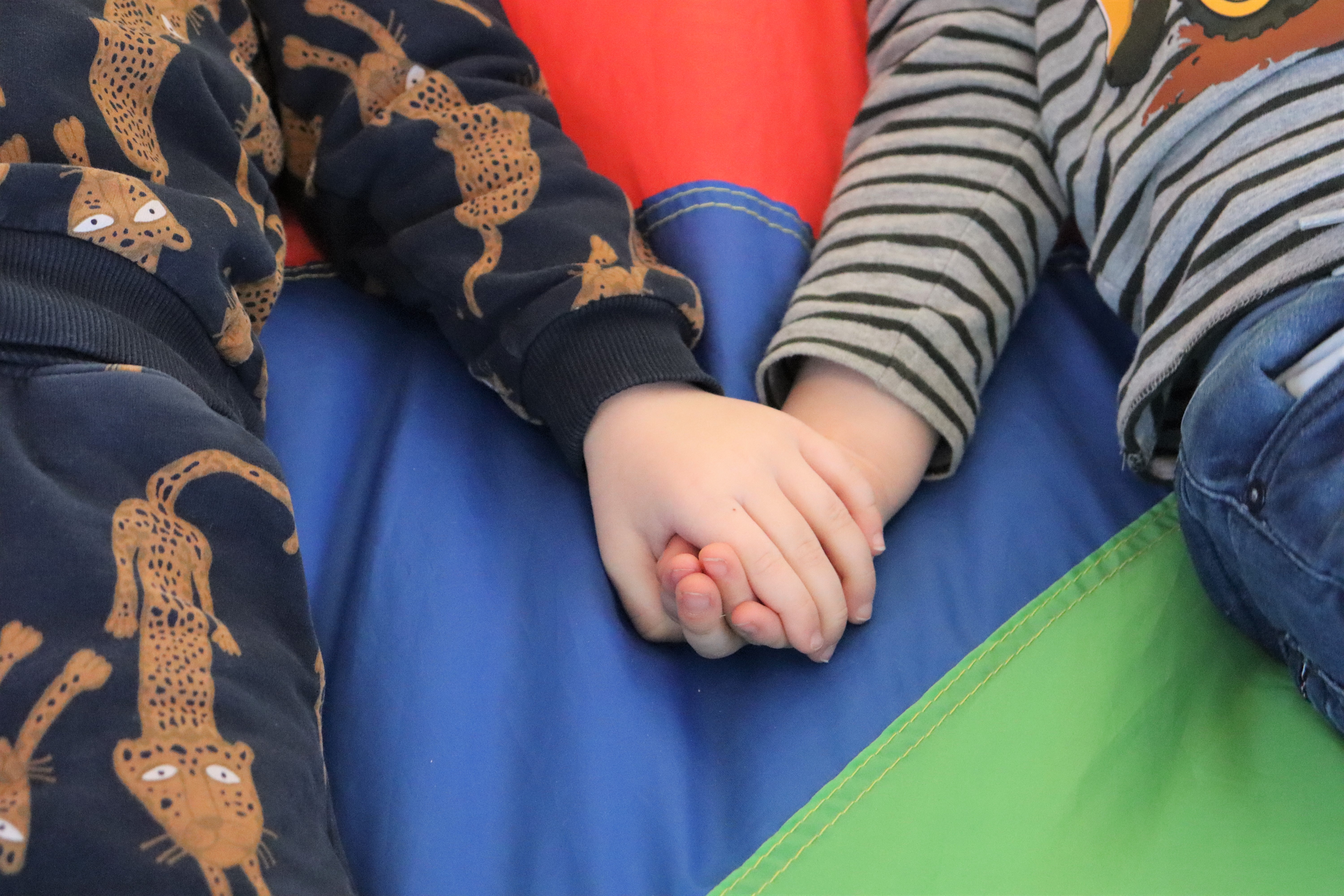 To børn holder hånd, hvor der er fokus på hænderne 